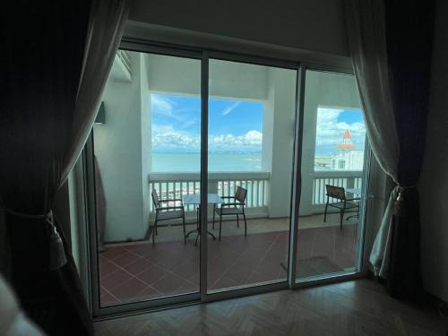 a room with a balcony with a view of the ocean at 2Bedroom Seaview @ Straits Quay in Bagan Jermal