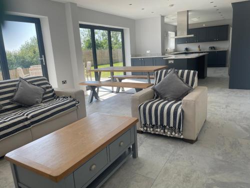 a living room with two couches and a table at Beautiful Executive Home in Llanelli