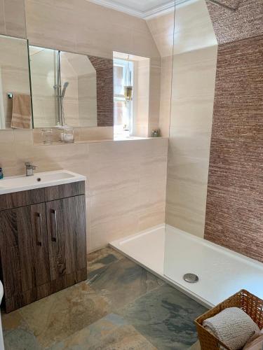 a bathroom with a bath tub and a sink at Pollokshields Burgh Hall Lodge Houses in Glasgow