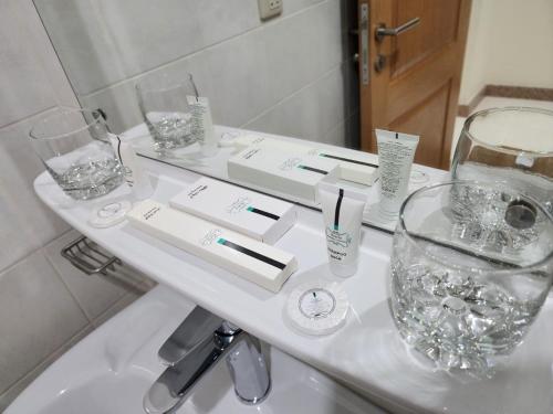 un baño blanco con gafas y lavabo en S Maskan Hotel en Dammam