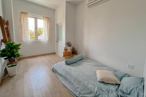 um quarto com uma cama num quarto com uma janela em La Maison em Ấp Tân An (2)
