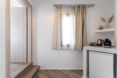 a white room with a window and a mirror at Naxian Air in Agios Georgios