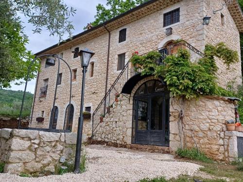 un antiguo edificio de piedra con una puerta y una luz de la calle en B&B Casal Cominium, en San Donato Val di Comino