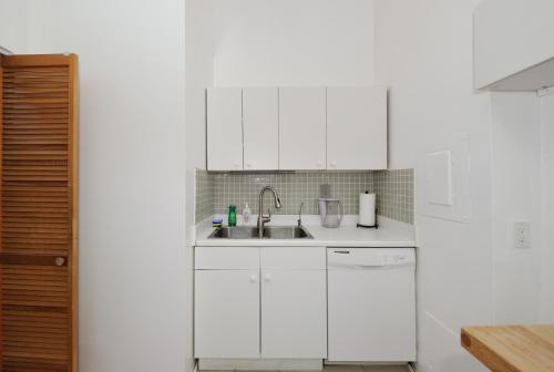 a kitchen with white cabinets and a sink at Beautiful 4BR 1Bath in Chamber Street NYC in New York