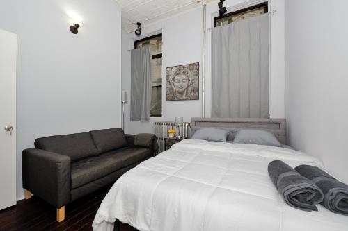 a bedroom with a large bed and a couch at Beautiful 4BR 1Bath in Chamber Street NYC in New York