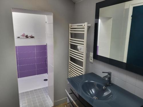 een badkamer met een wastafel en een spiegel bij Justicou in Poullaouen