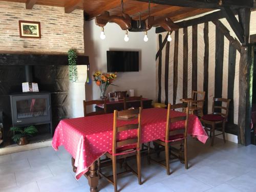 une salle à manger avec une table et des chaises et une cheminée dans l'établissement La Tuillière, à Saint-Étienne-de-Puycorbier