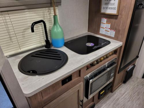 a kitchen counter with a sink and a vase on it at Island Breeze RV in Covington