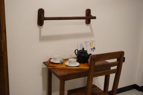 a wooden table with two cups and a tea pot on it at Nature World Jungle Paradise in Udawalawe
