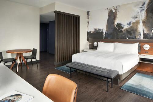 une chambre d'hôtel avec un lit, une table et des chaises dans l'établissement Marriott Owings Mills Metro Centre, à Owings Mills