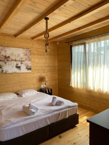 a bedroom with a large bed in a wooden room at морски вили Бендида къмпинг Гардения in Lozenets
