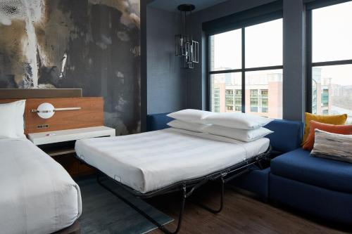 a bedroom with a bed and a blue couch at Marriott Owings Mills Metro Centre in Owings Mills