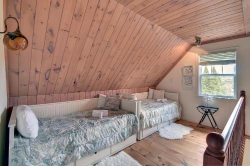 a bedroom with a bed and a wooden ceiling at The Golf & Mountain View Retreat by Instant Suites in Mont-Tremblant