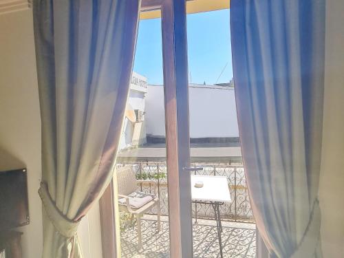 a view of a balcony from a window with curtains at SOFIA BOUTIQUE HOTEL in Kérynia