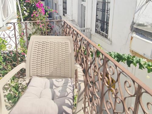 a white chair sitting on a balcony with flowers at SOFIA BOUTIQUE HOTEL in Kérynia