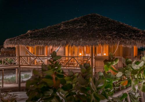 uma cabana com telhado de palha à noite em Jaguaribe Lodge e Kite em Fortim