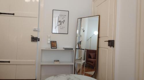 een witte kamer met een spiegel en een stoel bij Stadthaus Zimmer 6 neben dem REM-Museum in Mannheim Mitte in Mannheim