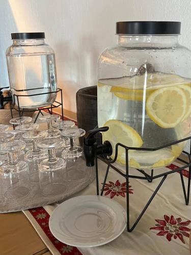 a table with a glass jar filled with water and lemons at La Roche Hotel Appartments in Aosta