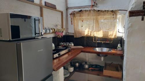 a small kitchen with a refrigerator and a sink at 11 Mountain Stream Hot Tub Self Catering in Gordonʼs Bay