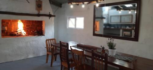 a dining room with a table and a fireplace at 11 Mountain Stream Hot Tub Self Catering in Gordonʼs Bay