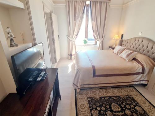 a bedroom with a bed and a television and a window at SOFIA BOUTIQUE HOTEL in Kérynia