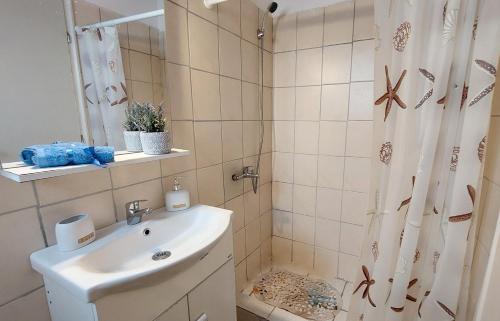 a bathroom with a sink and a shower with a shower curtain at Captain's Sea View in Vathi