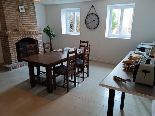 une salle à manger avec une table et une cheminée dans l'établissement A l'Ombre des Bois, Chambre double confort, à Neung-sur-Beuvron