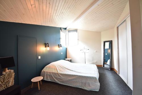 une chambre avec un lit et un mur bleu dans l'établissement Thais - Hossegor très agréable villa avec piscine située dans un quartier résidentiel, à Soorts-Hossegor