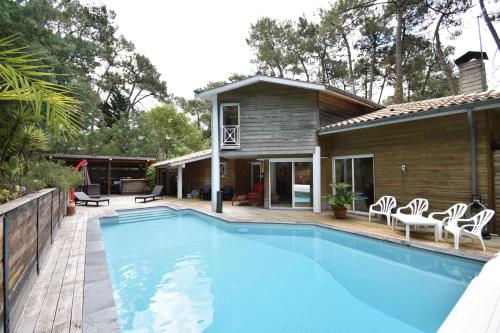une piscine devant une maison dans l'établissement Thais - Hossegor très agréable villa avec piscine située dans un quartier résidentiel, à Soorts-Hossegor
