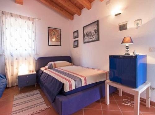 a bedroom with a bed and a table and a television at Incantevole villa full optional all'Isola d'Elba in Marina di Campo
