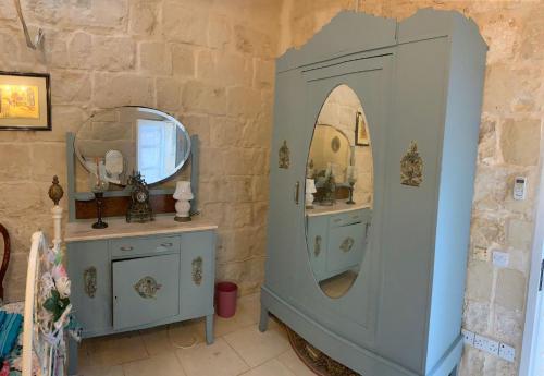 a bathroom with a mirror and a blue cabinet at Unique House of Character in centre of Mosta in Mosta