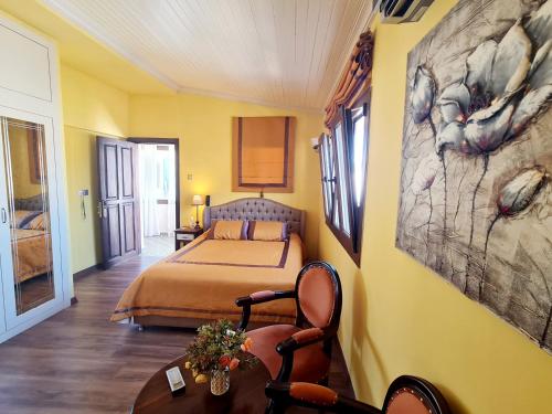 a bedroom with a bed and a table with a chair at SOFIA BOUTIQUE HOTEL in Kérynia