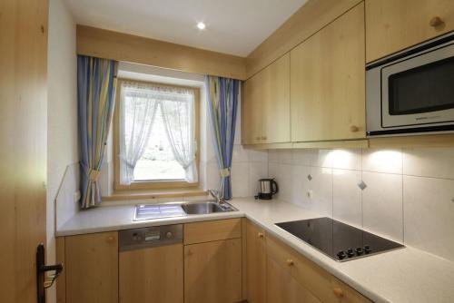 a small kitchen with a sink and a microwave at Pension Wendlhof in Obergurgl