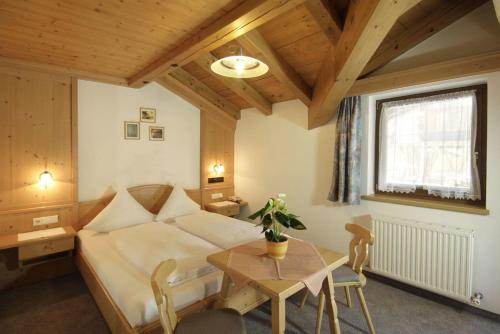 a living room with a bed and a table and a table sidx sidx at Pension Wendlhof in Obergurgl