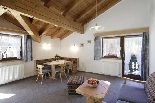 uma sala de estar com uma mesa, cadeiras e janelas em Pension Wendlhof em Obergurgl