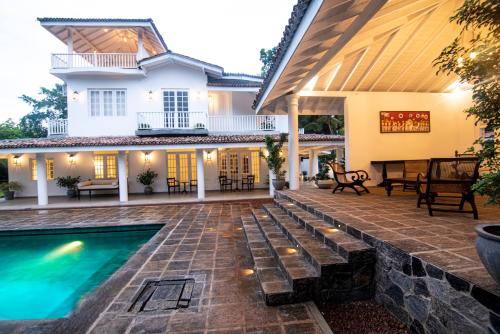 a patio with a pool and a house at The Villa By R in Balapitiya