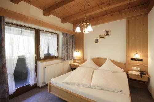 a bedroom with a bed and a large window at Pension Wendlhof in Obergurgl
