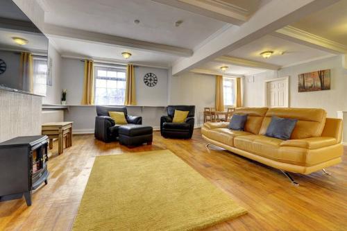 a large living room with a couch and chairs at 6 bedrooms, sleeps up to 16, secure parking space & comfort in Skegby