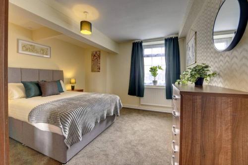 Un dormitorio con una cama grande y una ventana en 6 bedrooms, sleeps up to 16, secure parking space & comfort, en Skegby