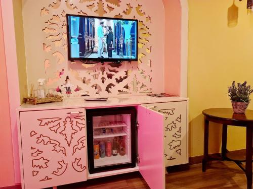 a pink refrigerator with a tv on top of it at SOFIA BOUTIQUE HOTEL in Kérynia