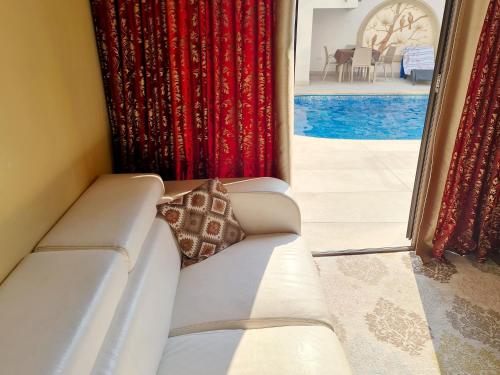 a white couch in a room with red curtains at SOFIA BOUTIQUE HOTEL in Kyrenia