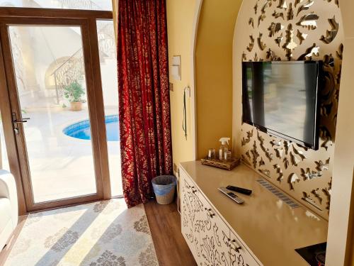 a living room with a tv and a sliding glass door at SOFIA BOUTIQUE HOTEL in Kyrenia