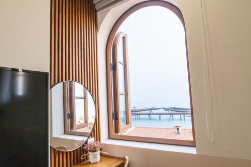 una ventana en una habitación con vistas al océano en Palo Santo Hotel Phu Quoc en Phu Quoc