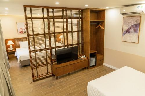 a hotel room with a television and a bedroom at Palo Santo Hotel Phu Quoc in Phu Quoc
