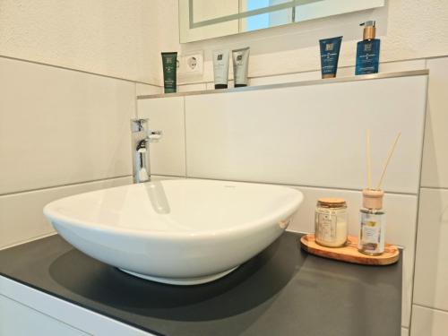 a bathroom with a white bowl sink on a counter at Homestay-Stylish, Zentral- Loft Apartment-Parking in Ingolstadt