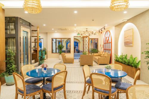 a lobby of a hotel with tables and chairs at Palo Santo Hotel Phu Quoc in Phu Quoc