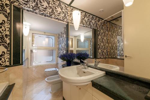 y baño con lavabo, aseo y espejo. en Piazza di Spagna 90 Exclusive Apartment en Roma