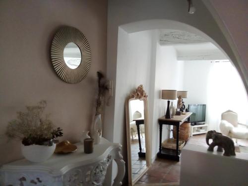 a living room with a mirror and a table at La maison perchee in Aigues-Mortes