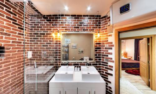 a bathroom with a brick wall and a white sink at VARNA KABAKUM HOUSE in Varna City