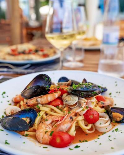 a plate of pasta with seafood and shrimp on a table at B&B Oasi Rooms in Agropoli